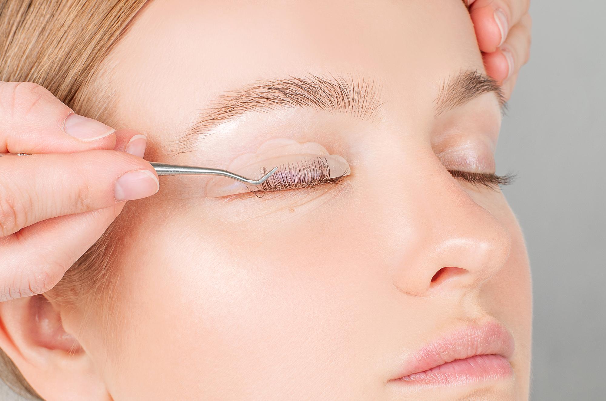 Woman doing eyelashes lamination, staining, curling, laminating and extension for lashes.
